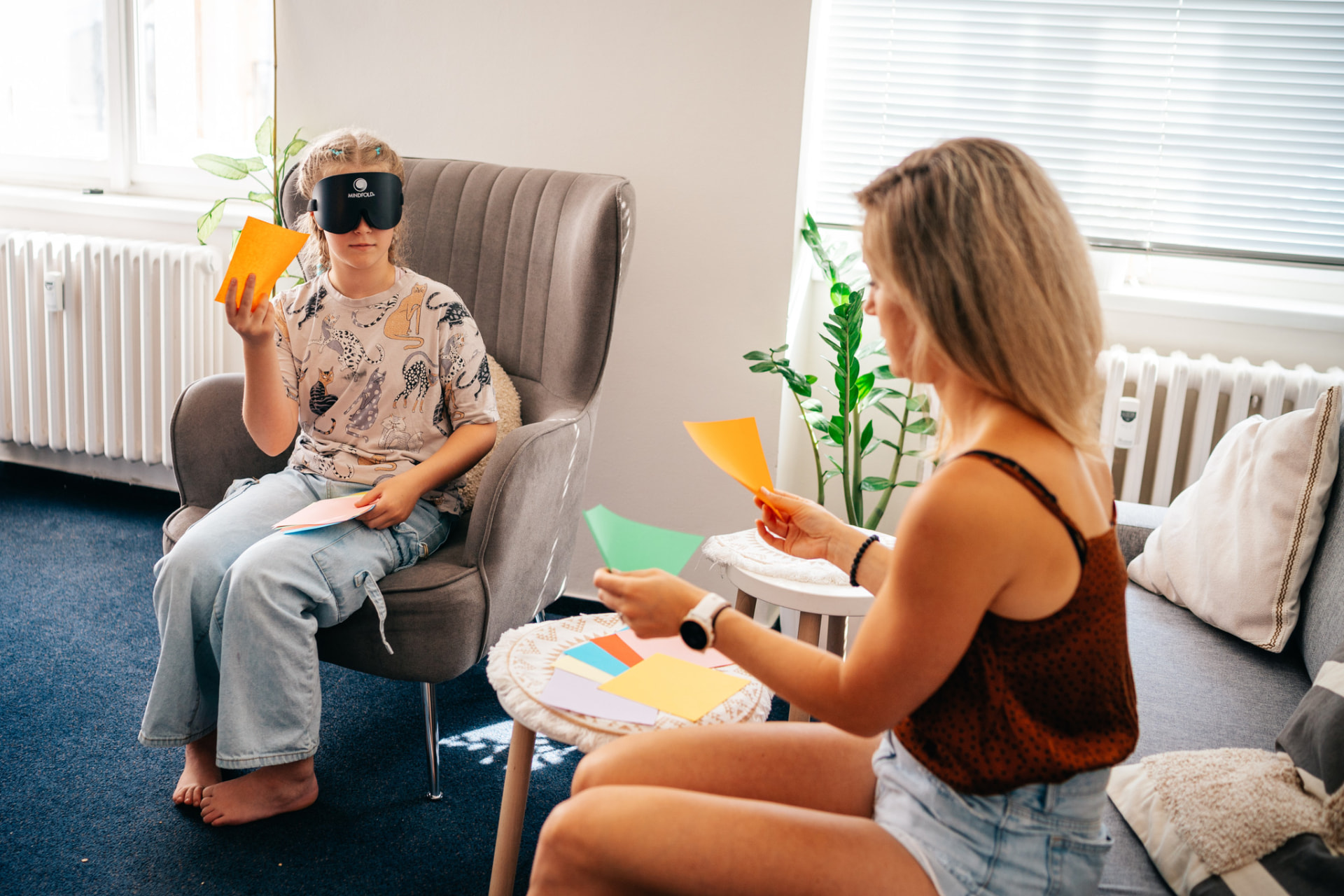 Dívka s maskou Mindfold v křesle rozpoznává barevné papíry při lekci EOV